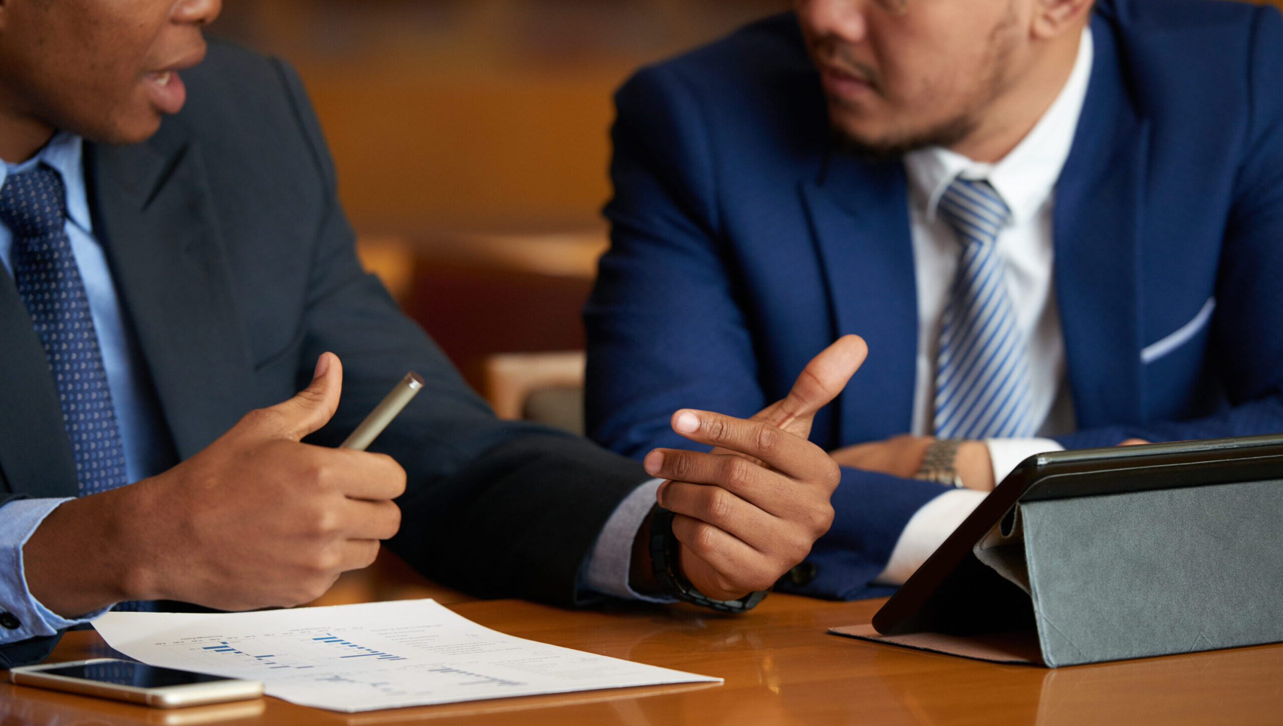 Cropped image of business people discussing financial report at meeting